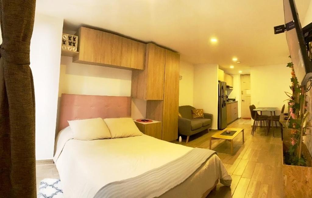 Un dormitorio con una cama y una sala de estar. en Bella Suit en La Candelaria en el corazón de Bogotá - Centro Histórico, en Bogotá