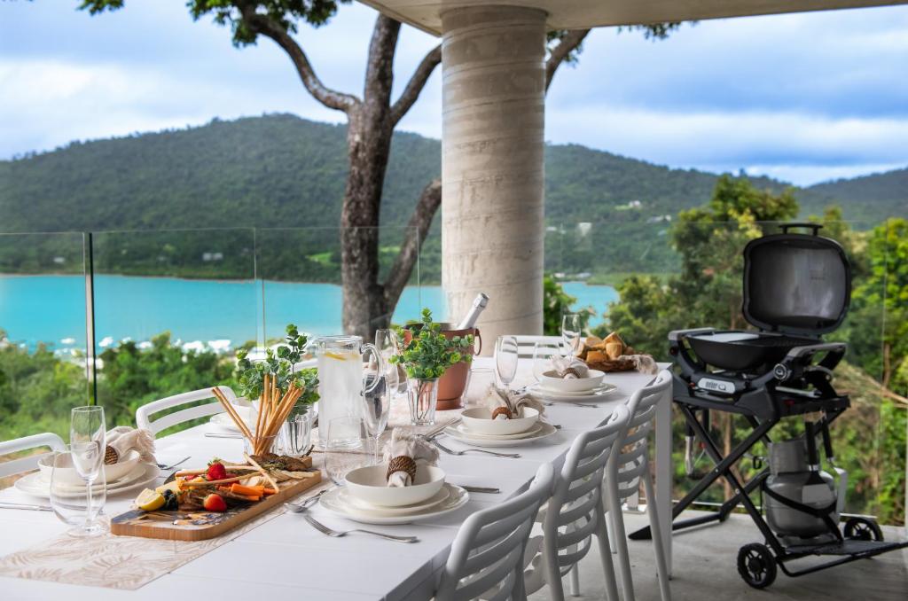 a table with a plate of food and a television at 23B Airlie View in Airlie Beach