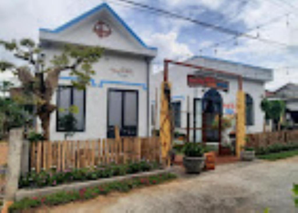 a white house with a fence in front of it at HomeStay Nhà E Phú Yên in Kon Rung (1)