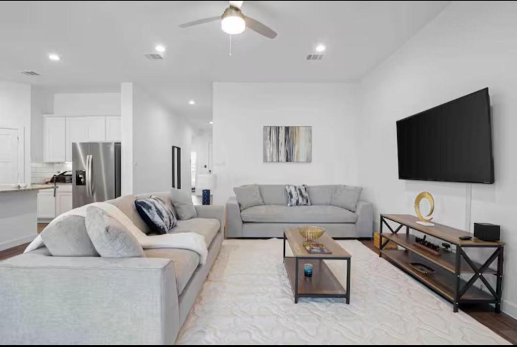 a living room with two couches and a flat screen tv at Sierra vacation house 1 in Katy