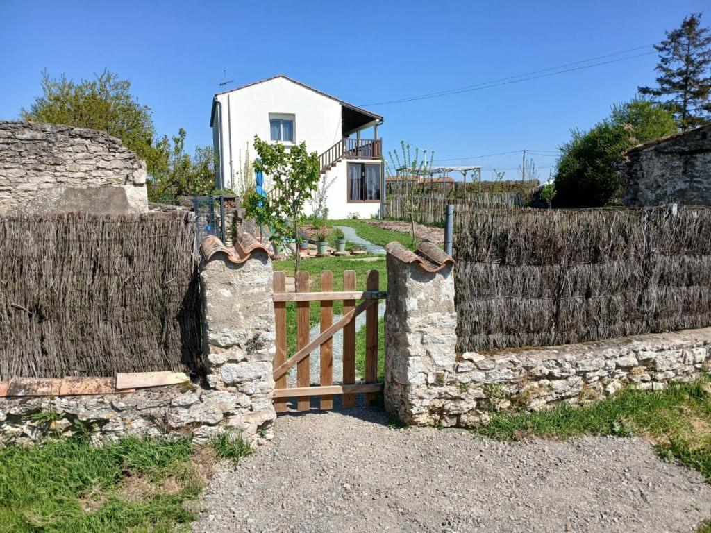 une clôture avec une porte en bois devant une maison dans l'établissement Chambre d'hôte avec salle de bain cosy au coeur du marais de Longeville-sur-mer, à Longeville-sur-Mer