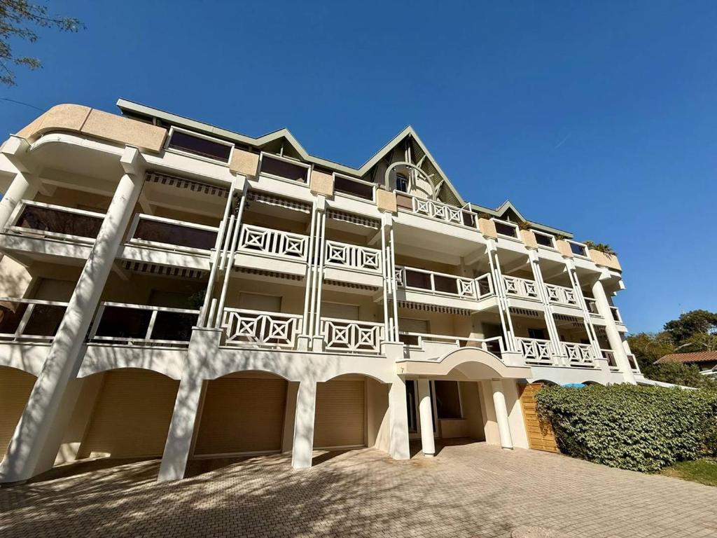 - un grand bâtiment blanc avec balcon dans l'établissement Arcachon: Appartement proche plages avec balcon et parking - FR-1-433-136, à Arcachon