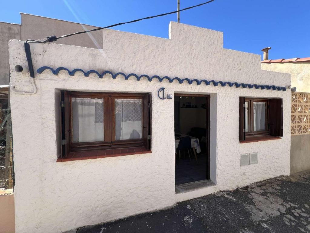 Cette petite maison blanche dispose d'une porte et de fenêtres. dans l'établissement Maison confortable proche centre, climatisée, 4 personnes - FR-1-701-88, à Valras-Plage