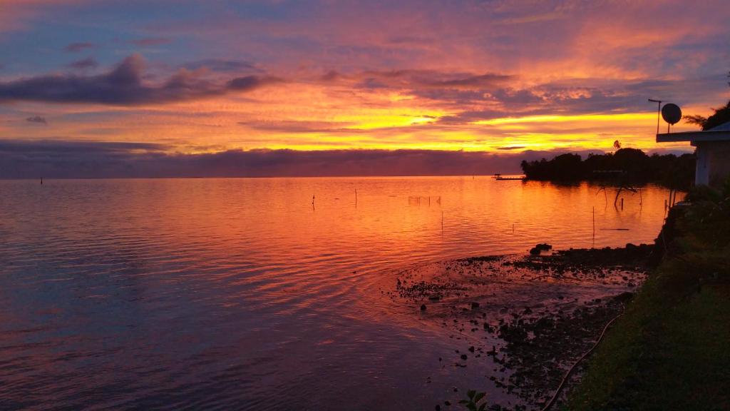 a sunset over a large body of water at Pension de famille HITI MOANA VILLA in Papara