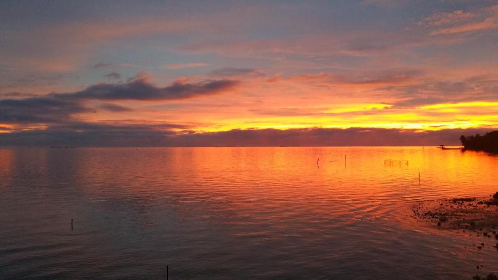 a sunset over a large body of water at Pension de famille HITI MOANA VILLA in Papara