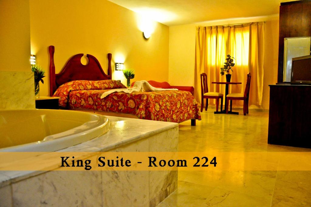 a bedroom with a king suite room with a bed and a tub at Hotel Marimba Punta Cana in Punta Cana