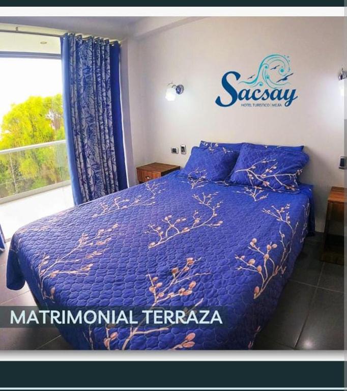 a bedroom with a blue bed and a window at Sacsay Mejía in Islay