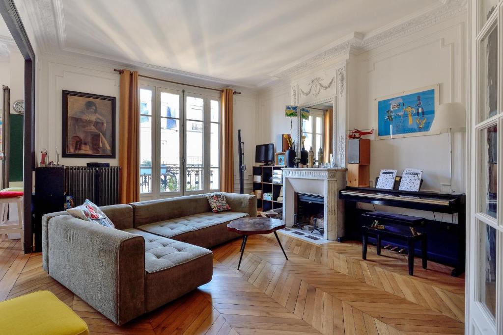 un salon avec un canapé et une cheminée dans l'établissement Appartement Poliveau - Welkeys, à Paris