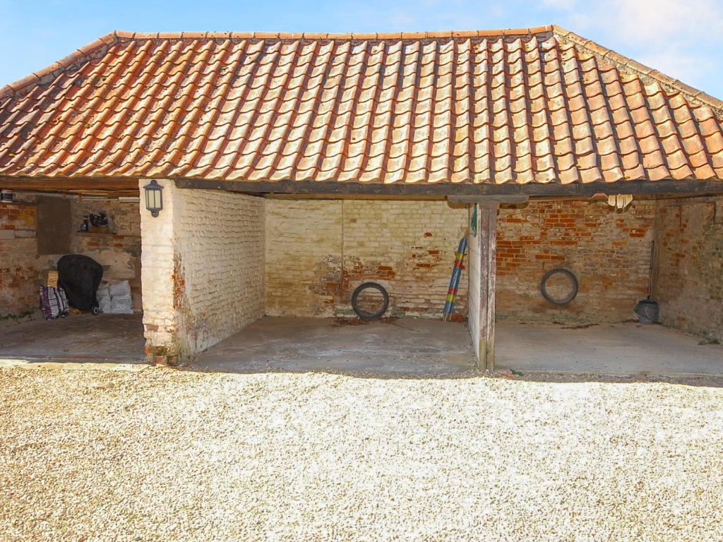an old brick building with a tile roof at Wherry Cottage in Wells next the Sea