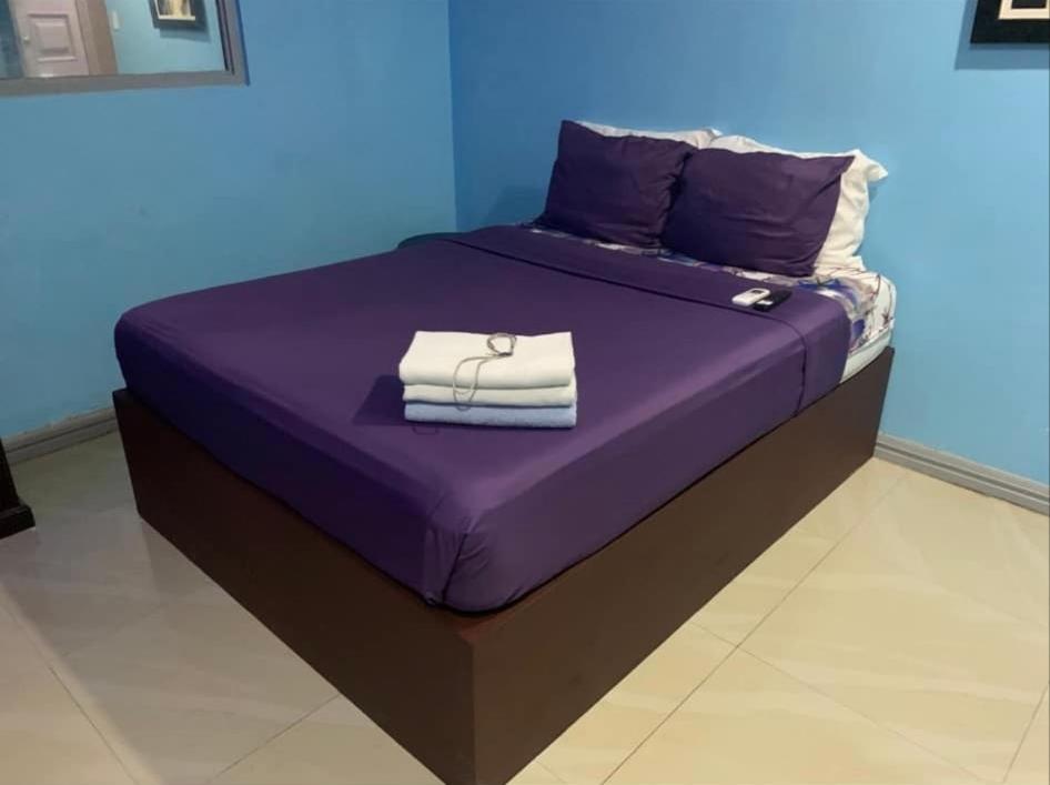 a purple bed with towels on top of it at Bourbon street condo in Angeles