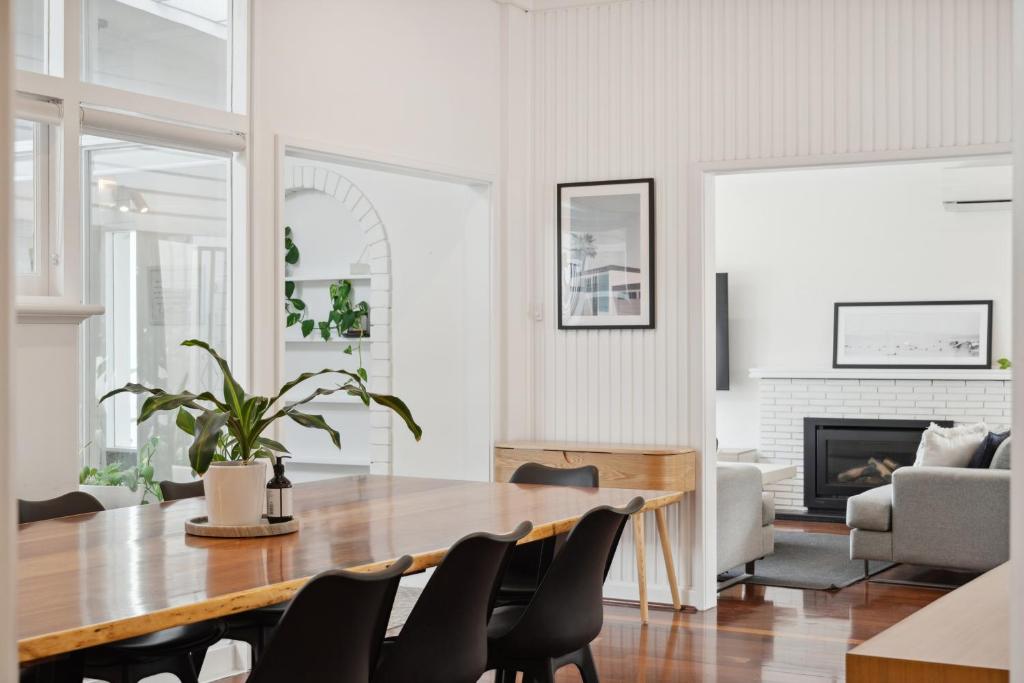 a living room with a table and chairs and a fireplace at Coastal Charm 2 Bedroom with Space to Move in Perth
