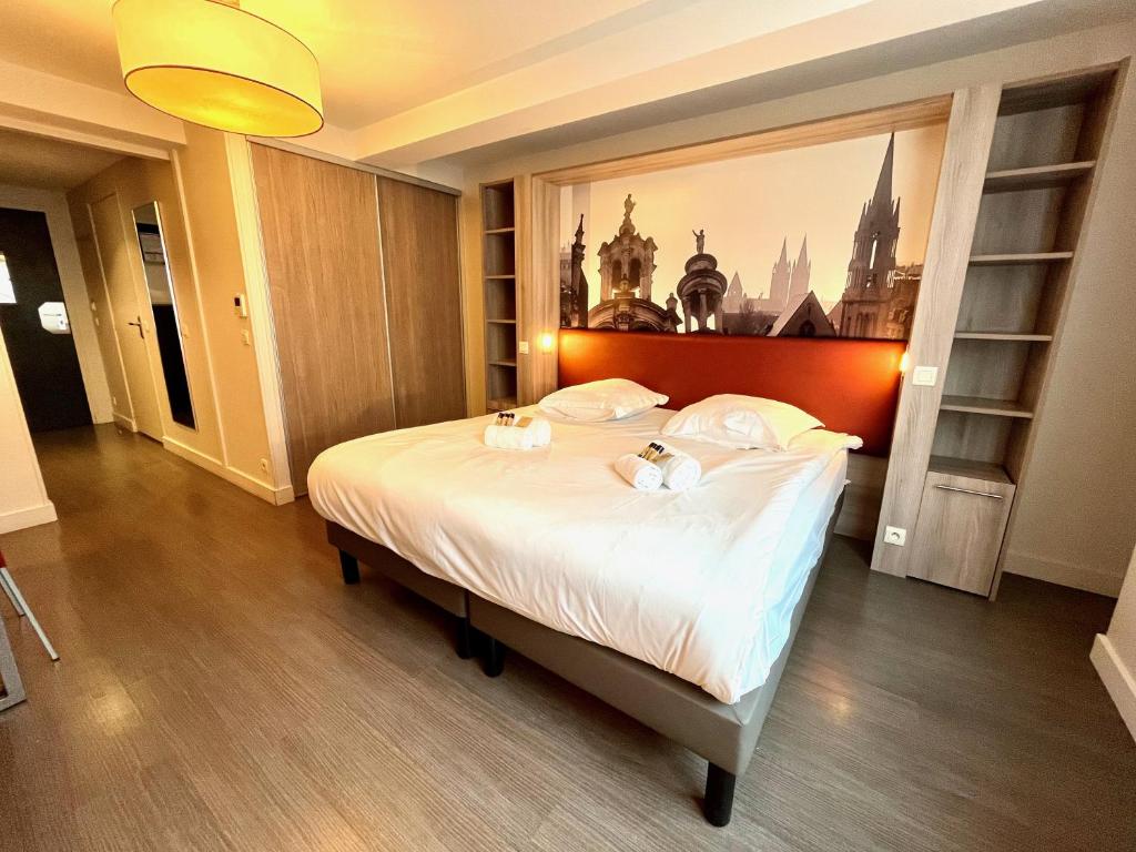 une chambre avec un grand lit avec des draps blancs dans l'établissement Joli studio sur les quais, à Caen