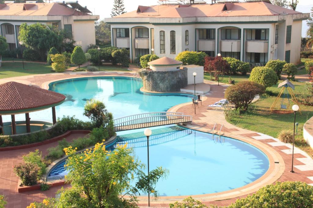 an overhead view of a swimming pool in front of a building at Blue Country Resort in Panchgani
