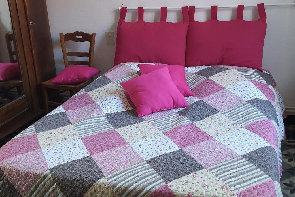 un letto con cuscini rosa sopra di La fermette d'etinehem a Étinehem