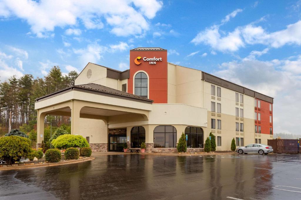 a building with a car parked in a parking lot at Comfort Inn North of Asheville in Mars Hill