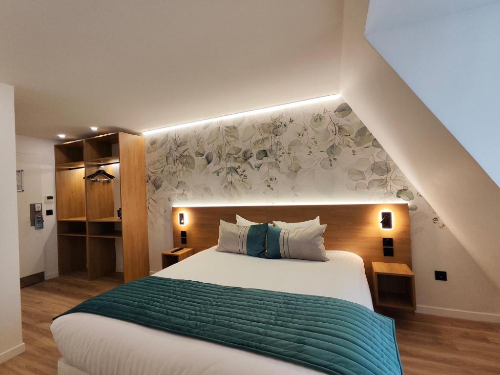 a bedroom with a large bed with a green blanket at 55 Hôtel Montparnasse in Paris