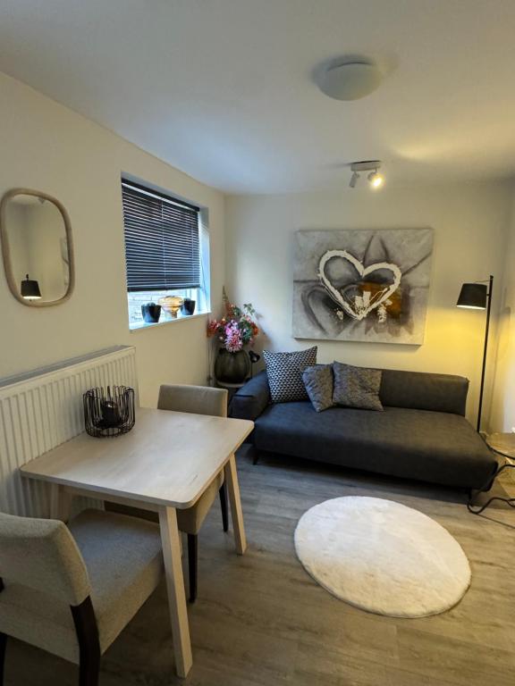 Hello Noordwijk - Zomerhuis Toekomststraat 8 في نوردفايك أن زي: غرفة معيشة بها أريكة وطاولة