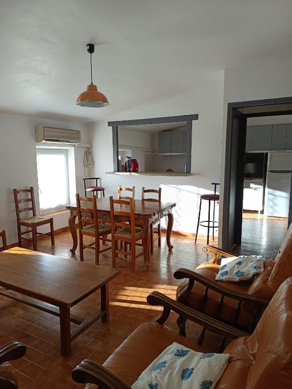 - un salon avec des chaises en bois et une table dans l'établissement appartement de village 2nd étage, à Malaucène
