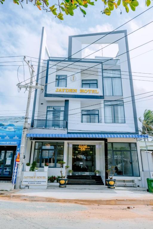 a white building with a sign on it at Jayden Hotel - Phú Quý in Îlot du Sud