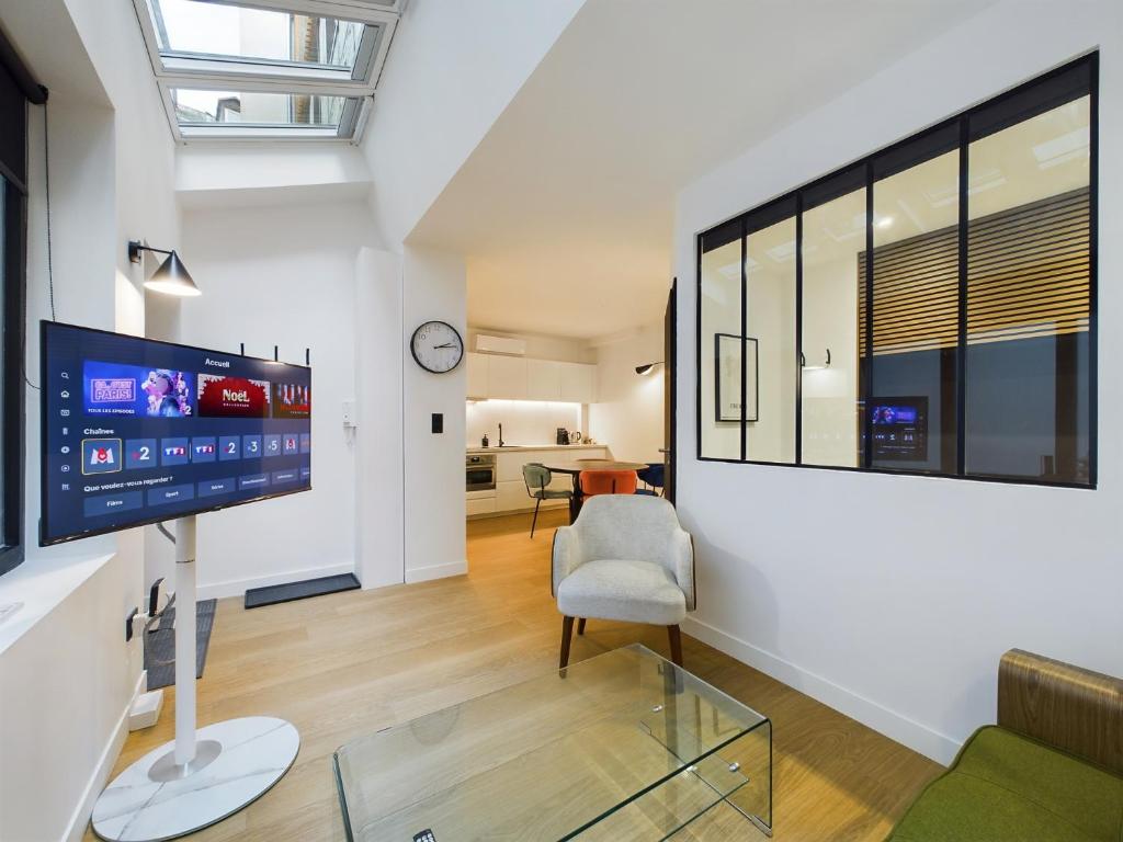 Hotel Loft neuf derrière la Cathédrale, a living room with a tv and a chair at Loft neuf derrière la Cathédrale in Strasbourg