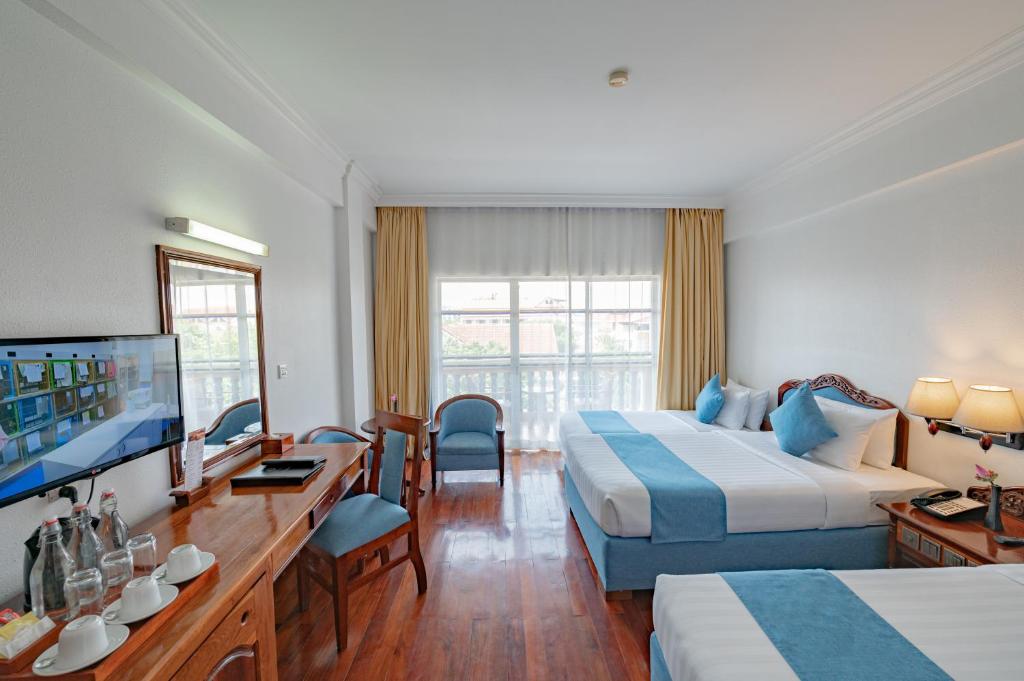 Postel nebo postele na pokoji v ubytování Hotel Somadevi Angkor Resort & Spa