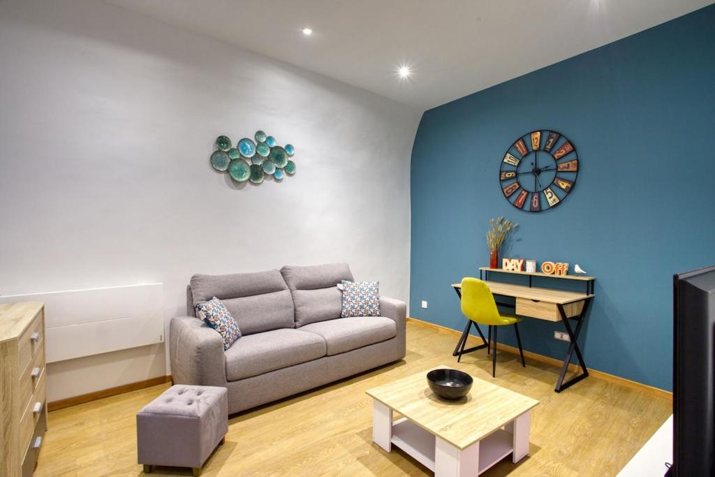 - un salon avec un canapé, une table et un réveil dans l'établissement Superbe, rénové, hyper centre, à Lyon