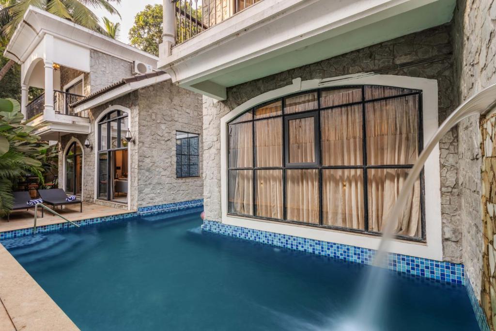 a swimming pool in front of a house at Casa da Paz by Hireavilla - Luxe 4BHK Villa near Morjim Beach in Morjim