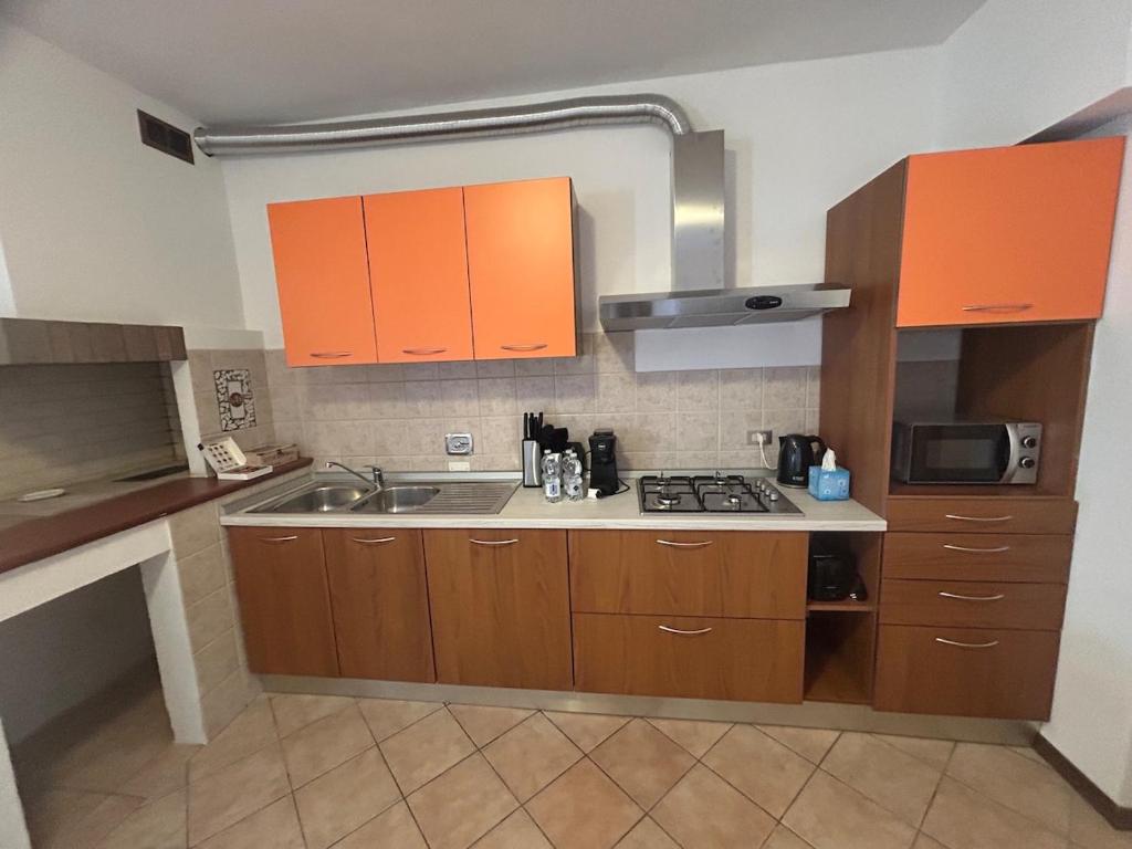 a kitchen with orange cabinets and a sink at Living Apartment-Centro Storico-Autodromo in Imola
