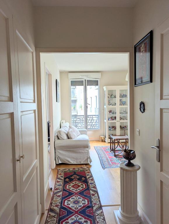 un salon avec un canapé et un tapis dans l'établissement Lumineux appartement centre ville avec parking et loggia, à Bordeaux