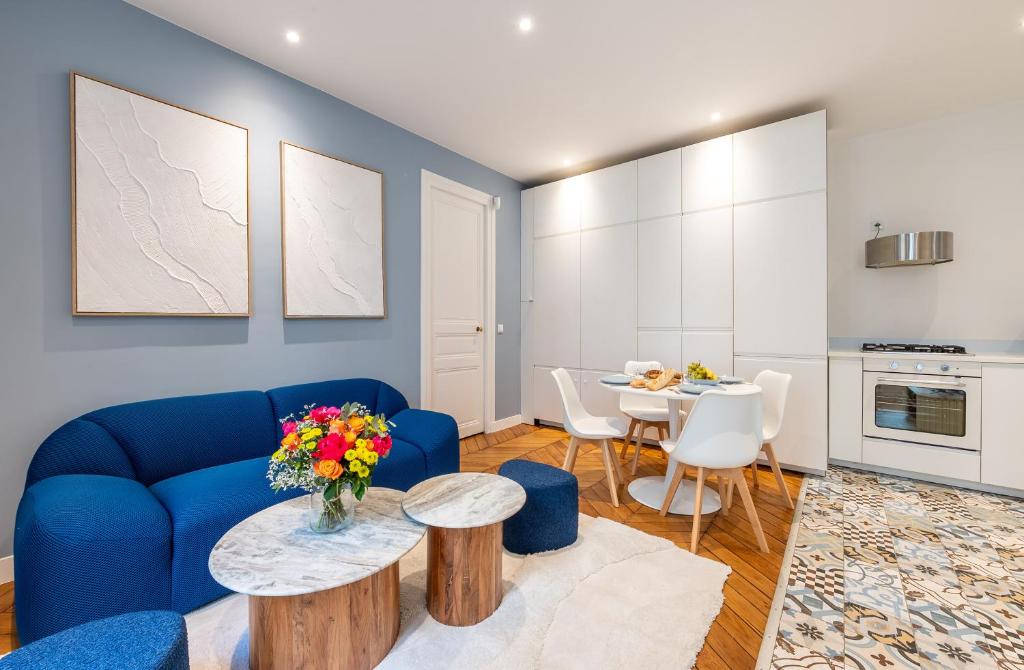 un salon avec un canapé bleu et une table dans l'établissement Mobility lease - Luxembourg Gardens & Montparnasse, à Paris