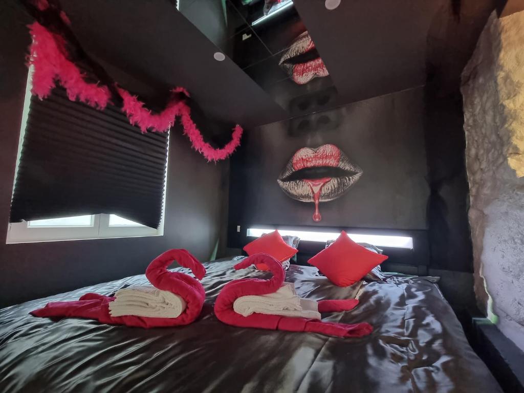 1 dormitorio con 1 cama con almohadas rojas y labios en Romantic Room proche de Paris, en Choisy-le-Roi