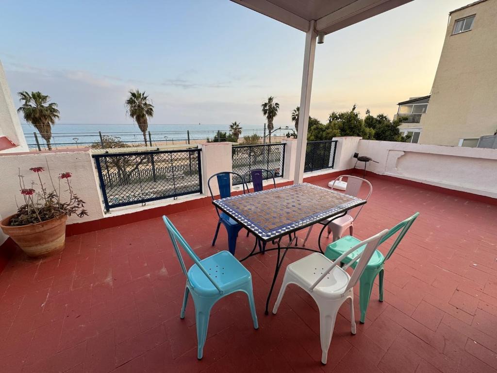 einen Tisch und Stühle auf einer Terrasse mit Meerblick in der Unterkunft Casa con vistas al mar y jardín in Canet de Mar