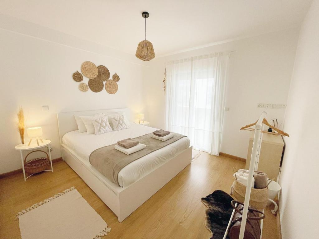 a white bedroom with a bed and a window at Casa C`Alma - Downtown Olhão Apartment with Pool in Olhão