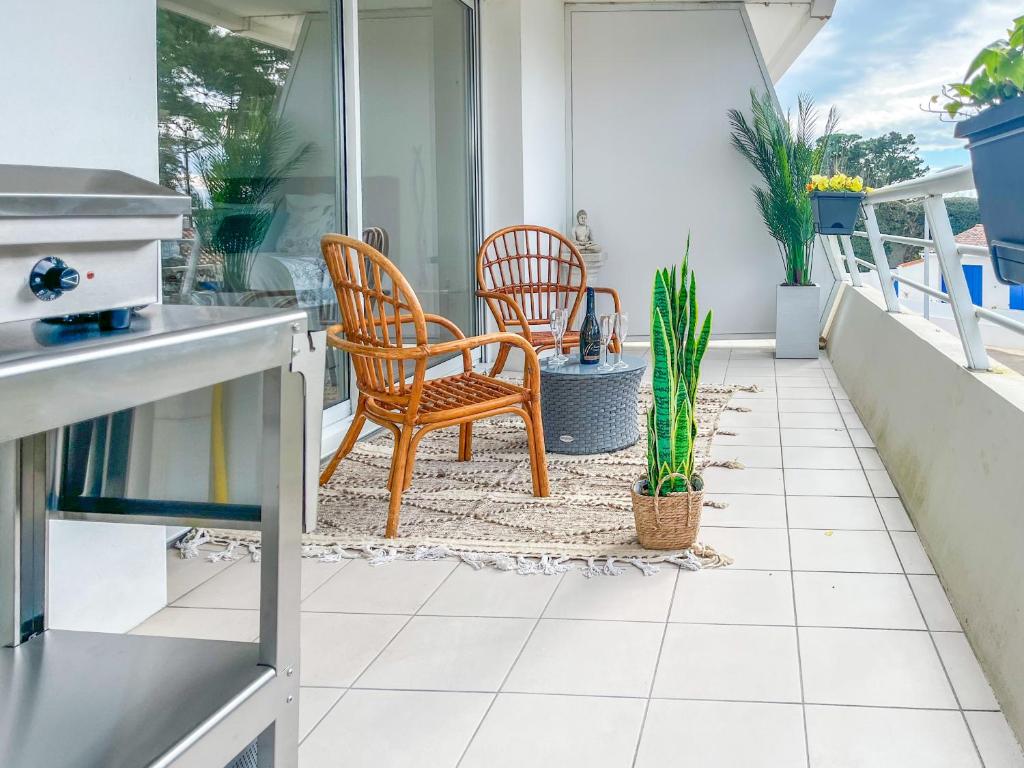 un balcon avec deux chaises et une table dans l'établissement Appartement spacieux et décoré avec goût - quartier Pironnière - 6 personnes, à Les Sables-dʼOlonne