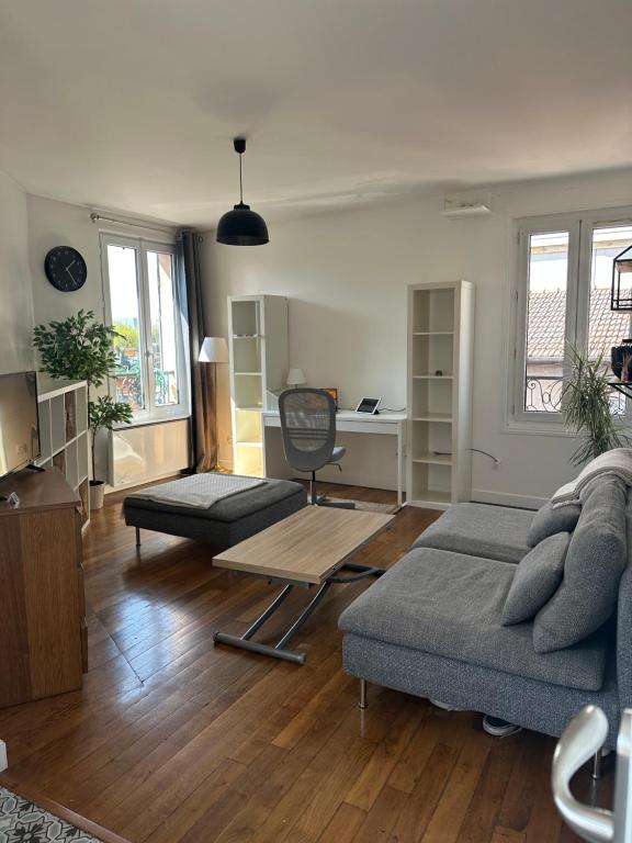 un salon avec un canapé et un bureau dans l'établissement Quiet cosy and large apartment with Terrace Top location, à Saint-Ouen