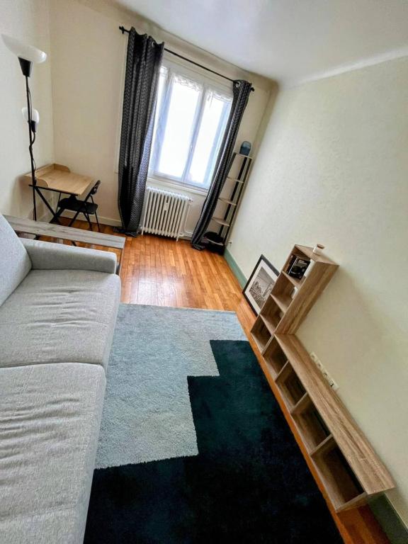 un salon avec un canapé et un miroir dans l'établissement Le Marceau, à Colombes