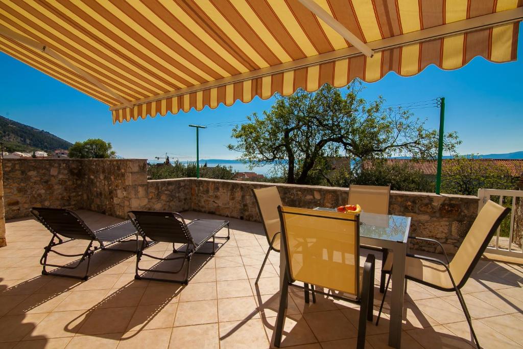 Dubas Studio Apartment في بول: فناء مع طاولة وكراسي تحت مظلة الفناء