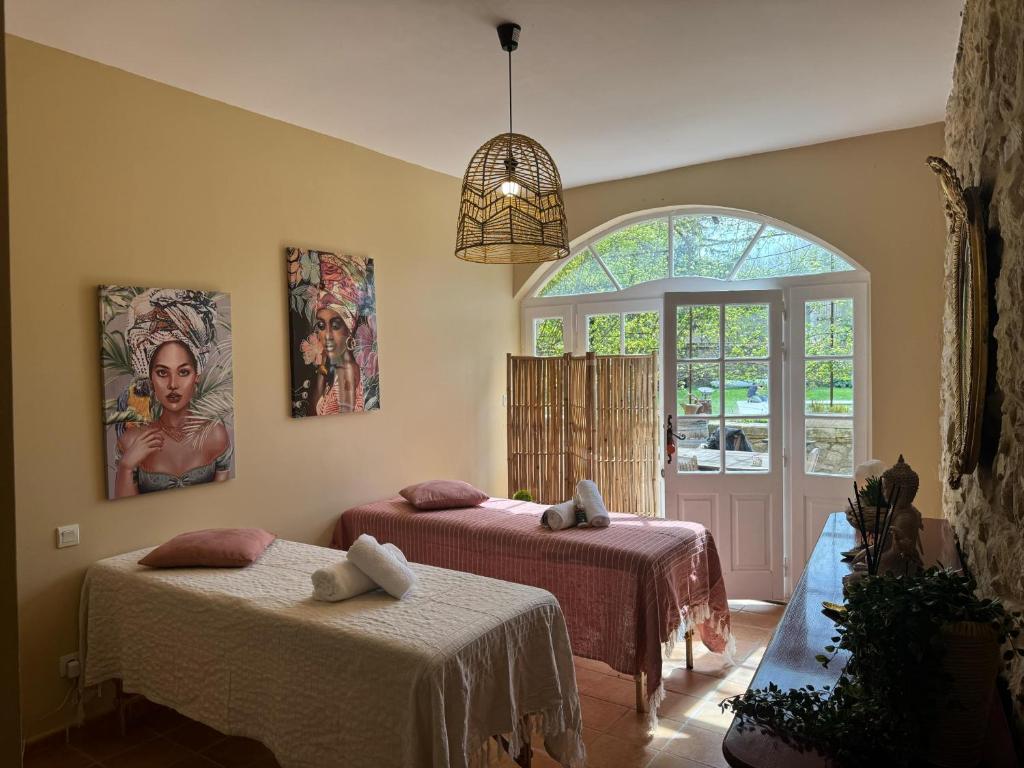 une chambre avec deux lits et une grande fenêtre dans l'établissement La villa des figuiers, à Saint-Bonnet-du-Gard