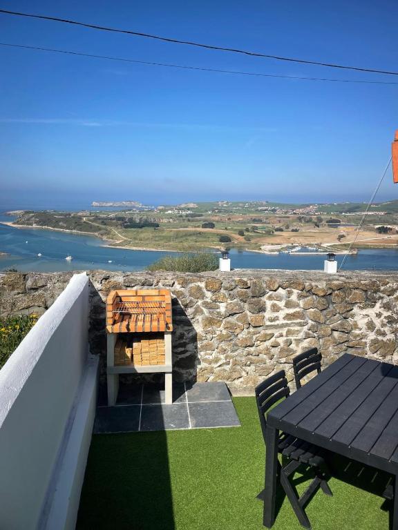 a table and chairs on a balcony with a view of the ocean at EL RINCÓN DE DENVER in Suances