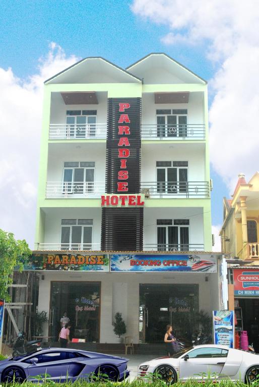 a building with a hotel with cars parked in front of it at Paradise Hotel in Phong Nha