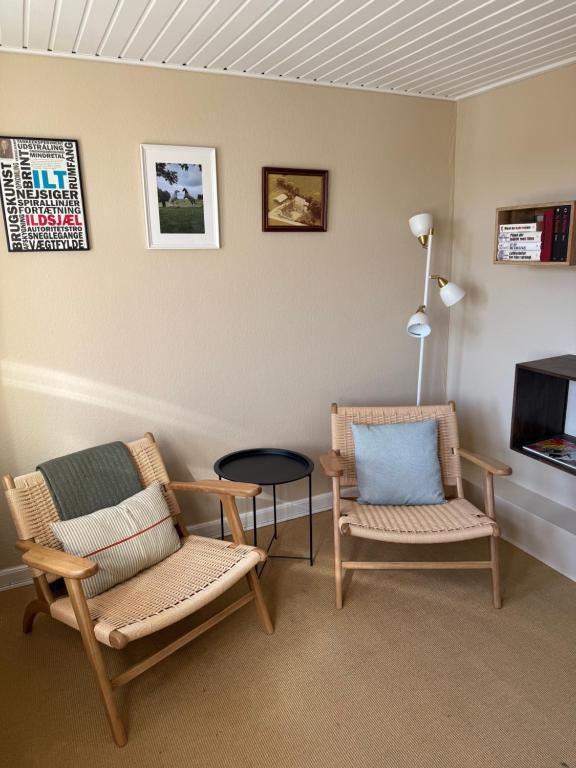 una camera con due sedie, un tavolo e una TV di Digebjerggaard Bed & Breakfast a Vester-Skerninge