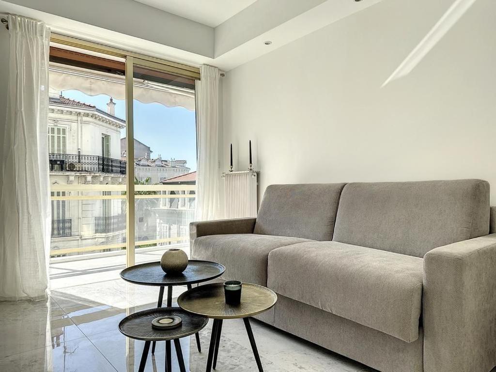 un salon avec un canapé et deux tables dans l'établissement Cannes Centre Mimosas 1 chambre Salon, à Cannes