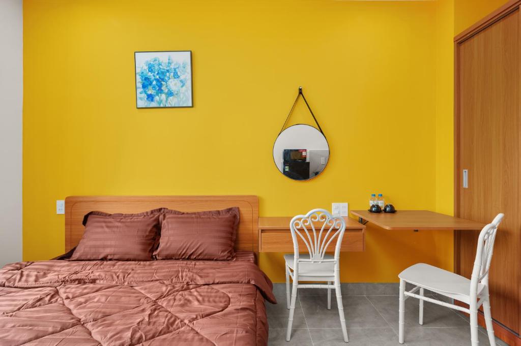 a bedroom with a bed and a desk and a mirror at Saluton House in Da Nang