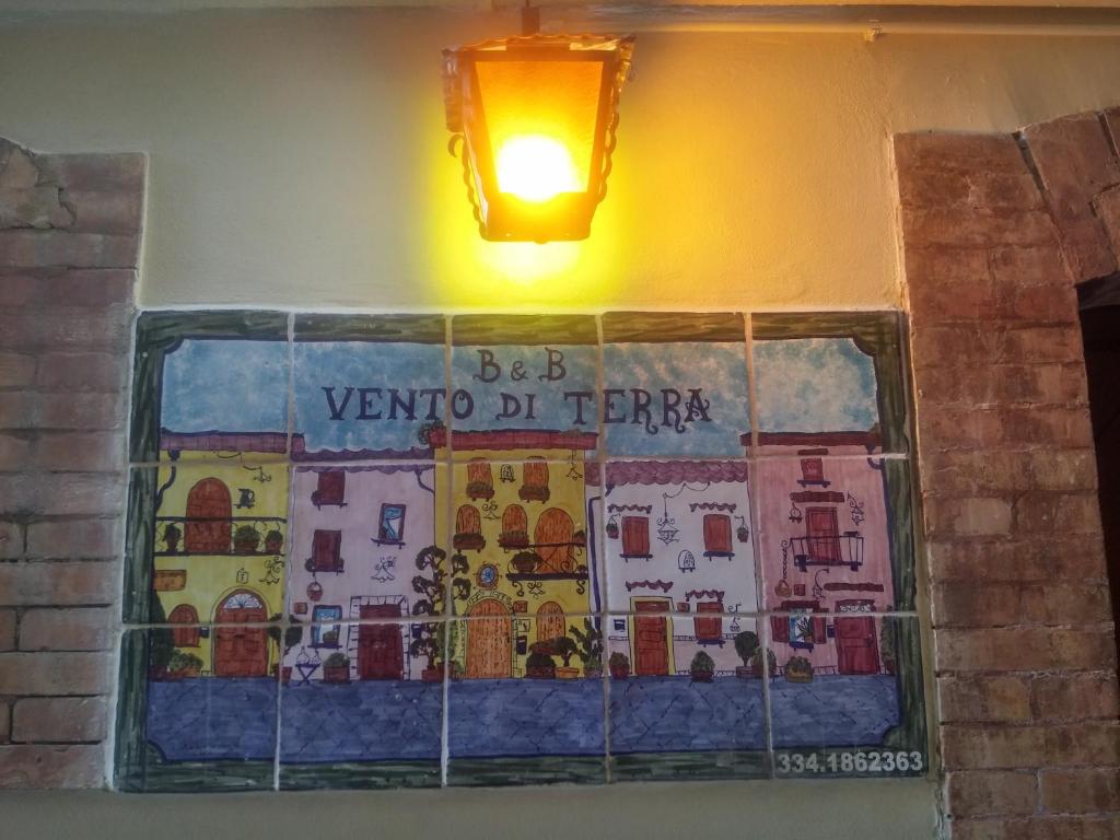 a tile on a wall with a light on it at B&B Vento di Terra in Gaeta