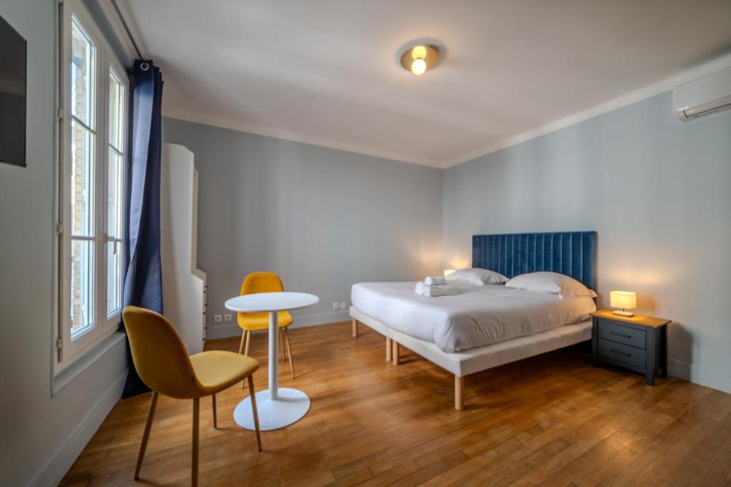 une chambre avec un lit, une table et des chaises dans l'établissement Majestic Suite, à Paris