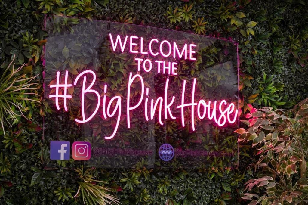 a neon sign that says welcome to the big pink house at Big Pink House in Mealsgate