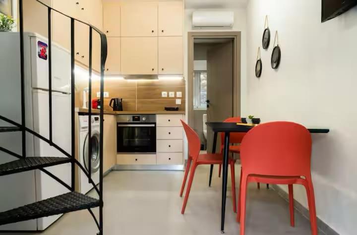 a kitchen with a dining table and red chairs at Burnelia Vacation Maisonette in Lefkímmi