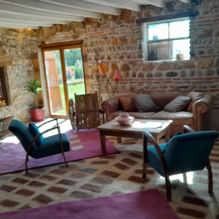 un salon avec un canapé, une table et des chaises dans l'établissement Le Moulin de Chamambard, à Saint-Denis-lès-Bourg
