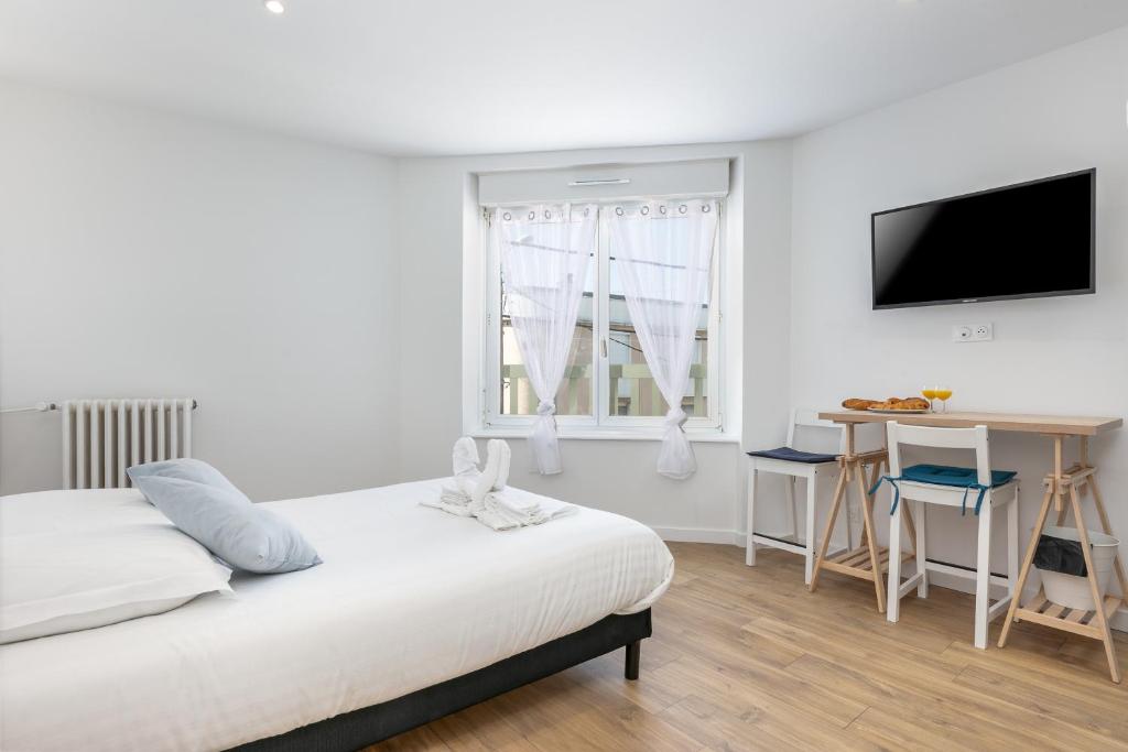 une chambre avec un lit, une table et une télévision dans l'établissement Marie-claudine, à Brest