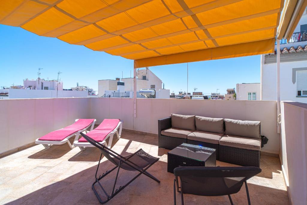 a patio with a couch and chairs on a roof at Casa Alegre by Casasol in Nerja